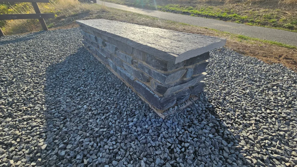 Nahaufnahme der Steinbank auf dem geschotterten Sitzplatz an der Insektenoase am Hinkelweg.
